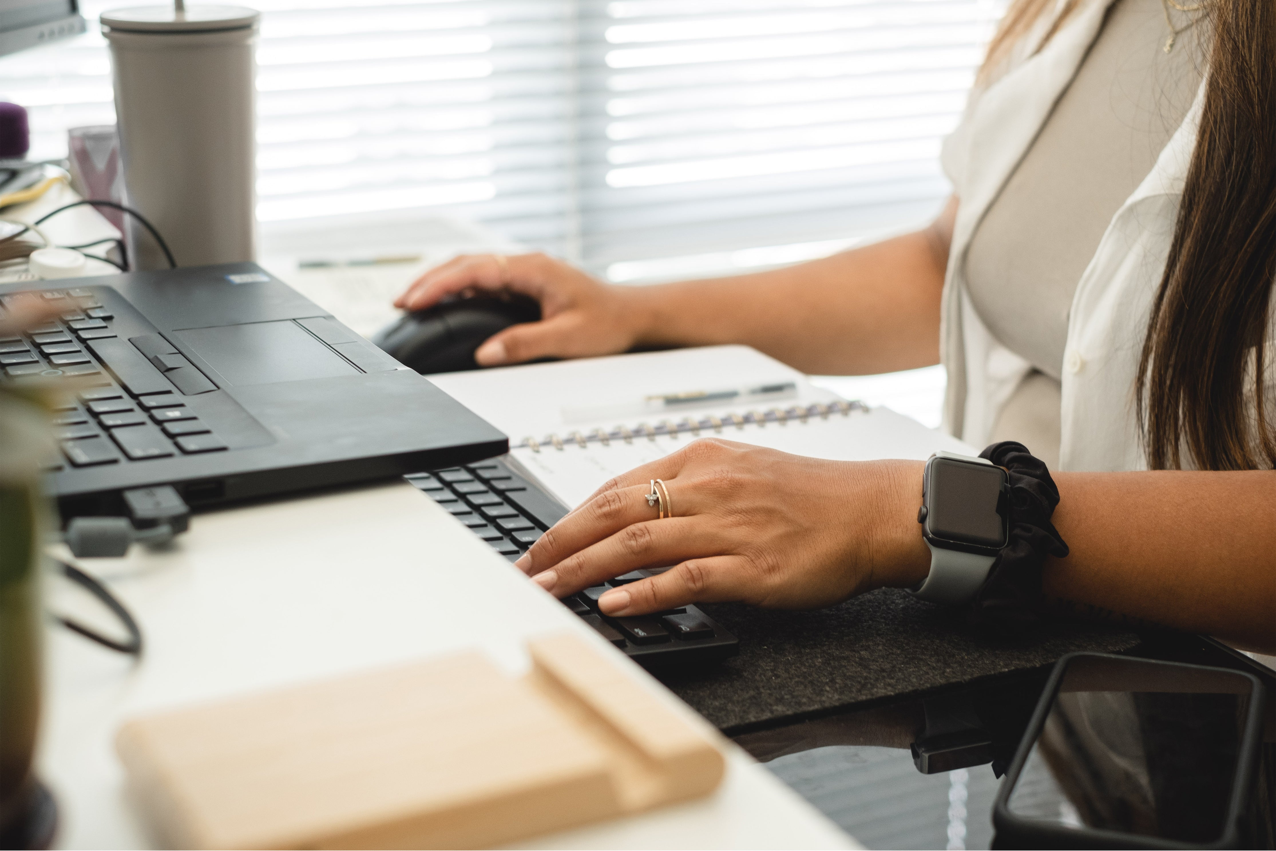 Persons hands working at a two tier desk