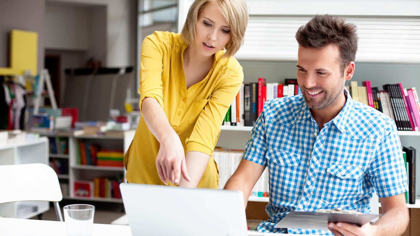Two coworkers reviewing a laptop together